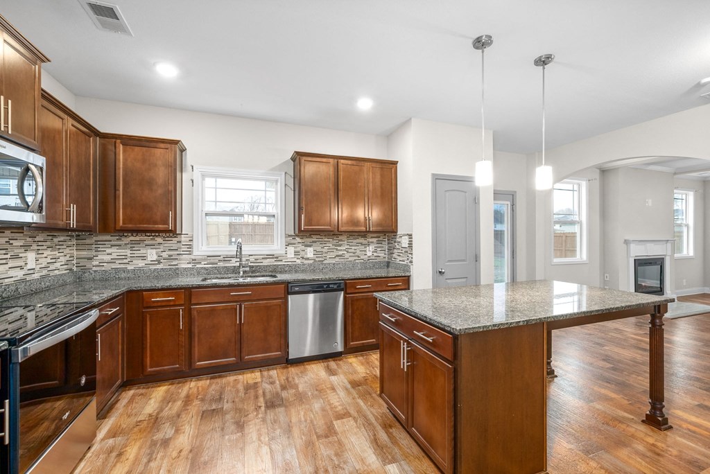 a kitchen with wooden cabinets and granite counter tops