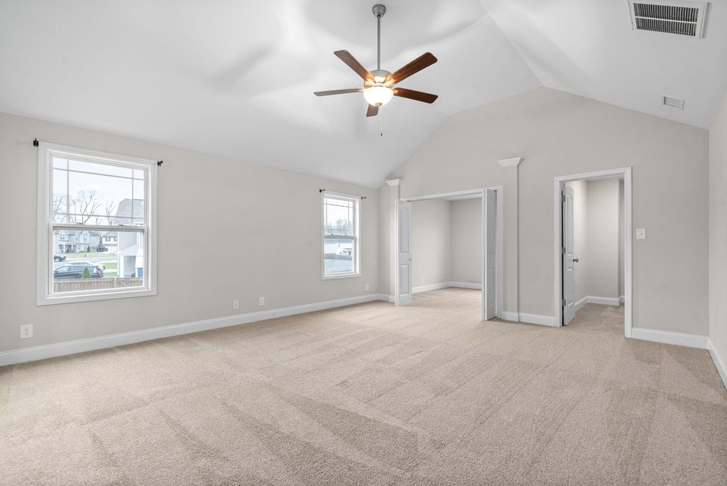 an empty living room with a ceiling fan