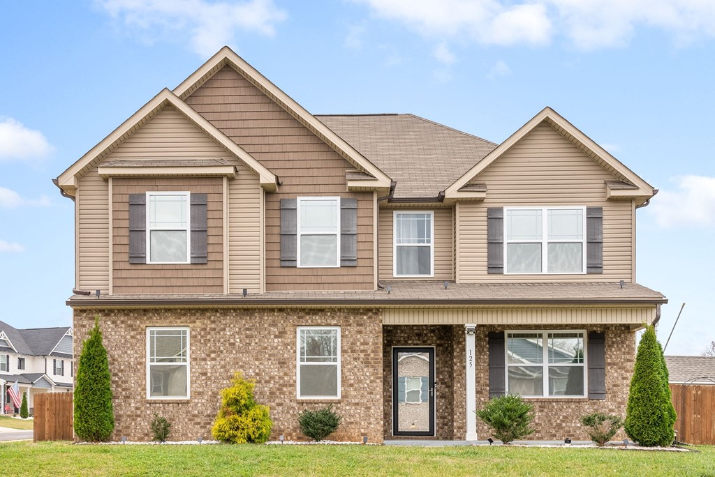 a tan house with brown siding and a brown roof