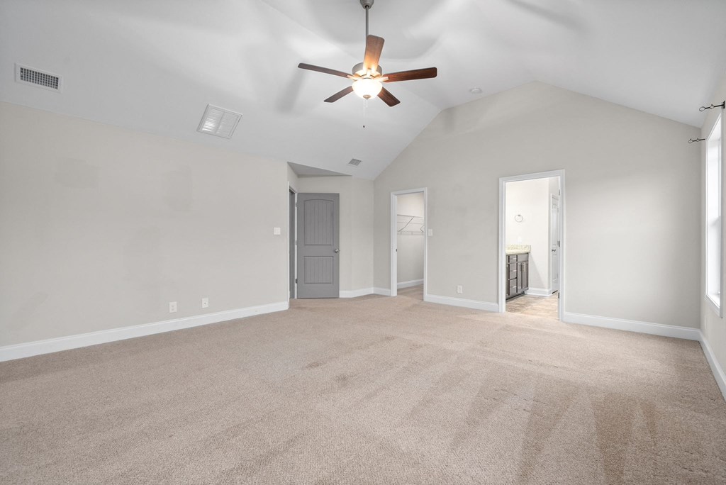 an empty living room with a ceiling fan