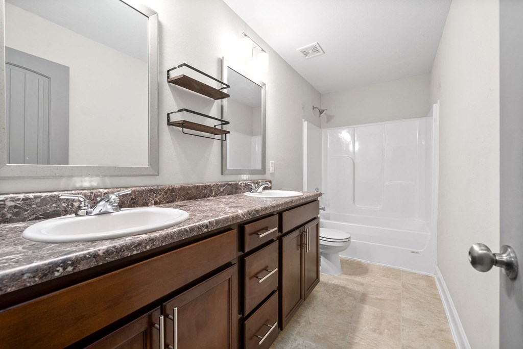 a bathroom with two sinks and a shower and a toilet