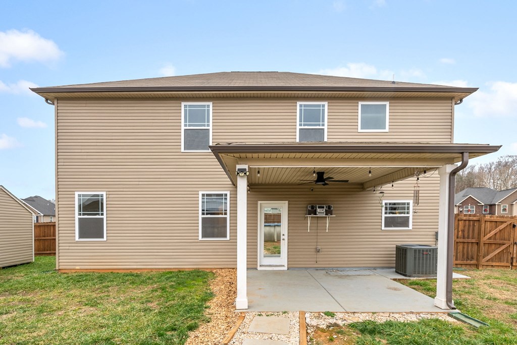 the front of a tan house with a concrete driveway