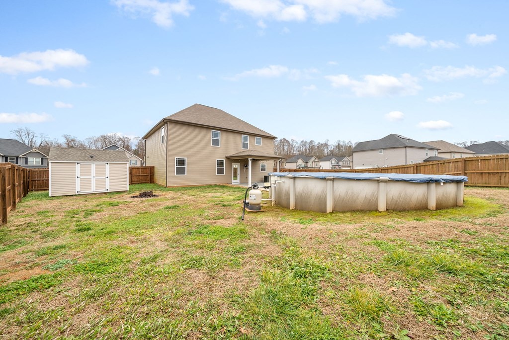 the backyard of a house with a pool and a fence