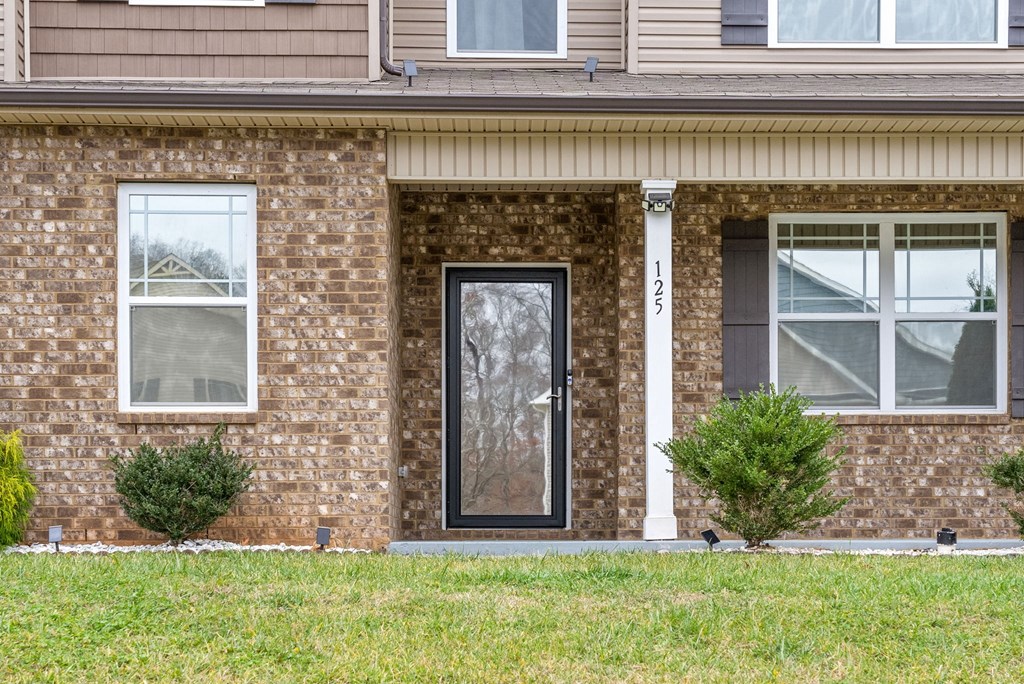 the front of a brick house with a black door