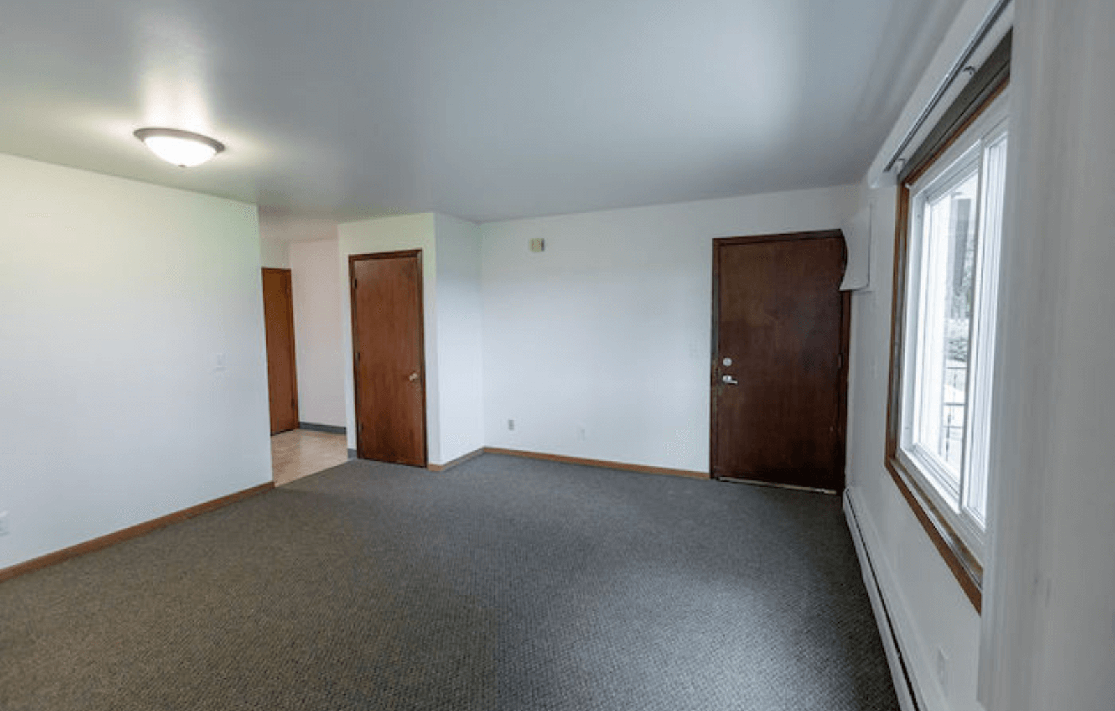 an empty room with a window and a door