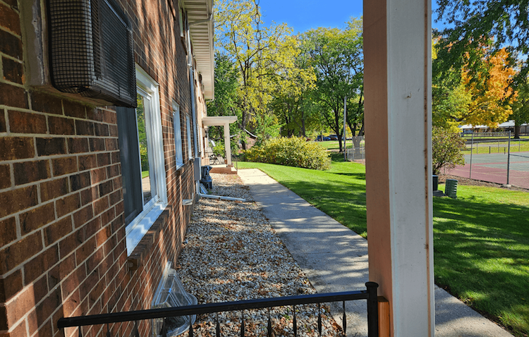 a view of the side of a brick building with a sidewalk