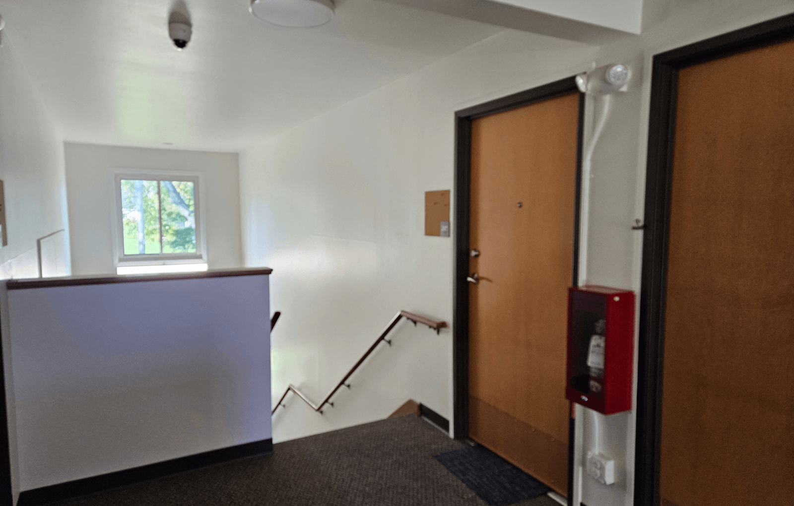 a room with a staircase and two doors and a window