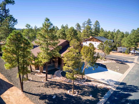 an aerial view of a house with a swimming pool and trees