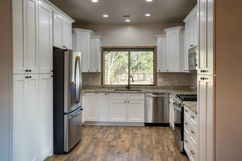 a kitchen with white cabinets and stainless steel appliances