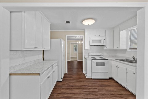 a white kitchen with white cabinets and white appliances