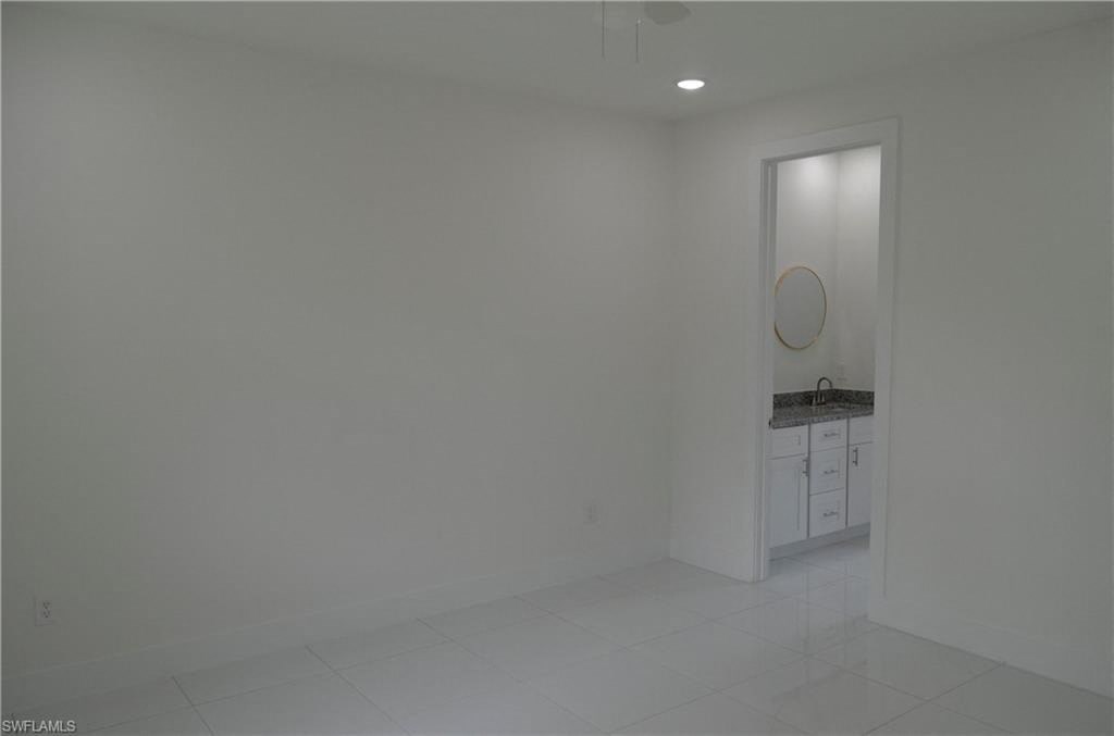 an empty room with a sink and a mirror