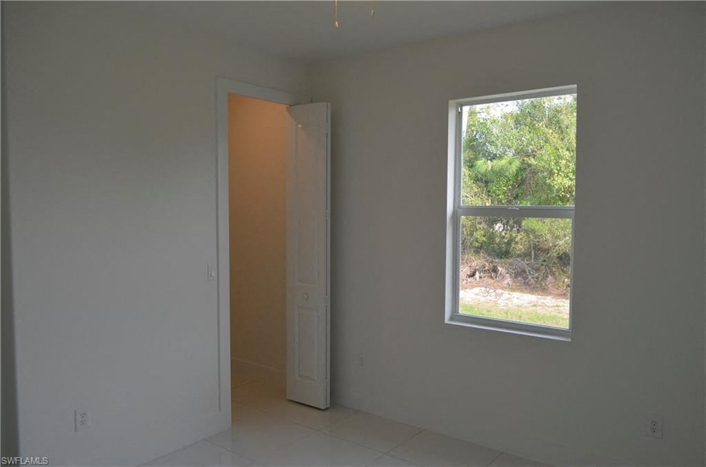 an empty room with a window and an open door