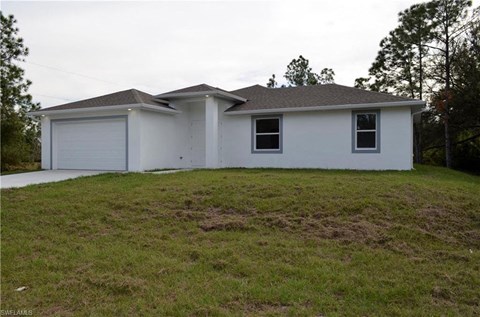 a white house on a hill with a garage