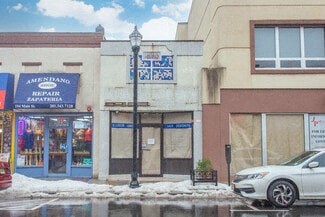 a city street with a car parked in front of a building