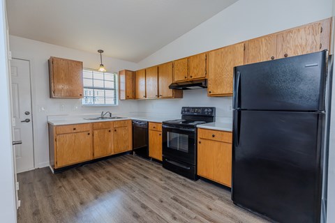 A kitchen with wooden cabinets and black appliances.