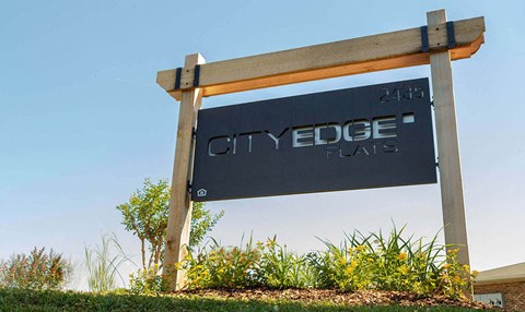 A sign for City Edge in front of a clear blue sky.