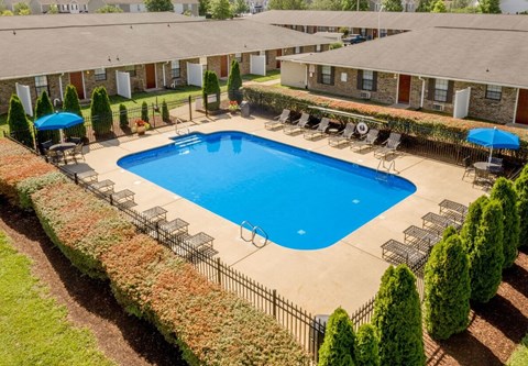 A swimming pool surrounded by a fence and trees.