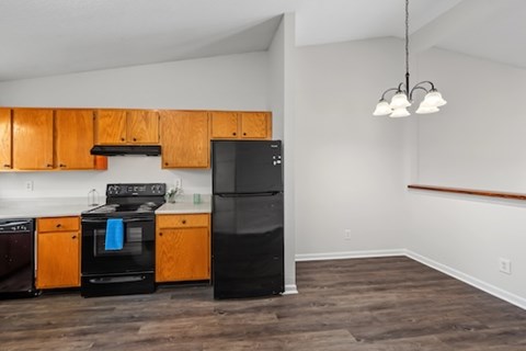 A kitchen with wooden cabinets and black appliances.