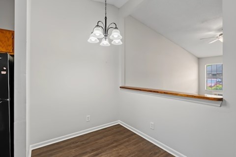 A room with a wooden floor and a window with a view of a building outside.