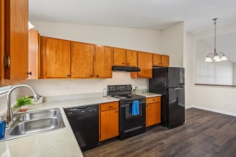 A kitchen with black appliances and wooden cabinets.