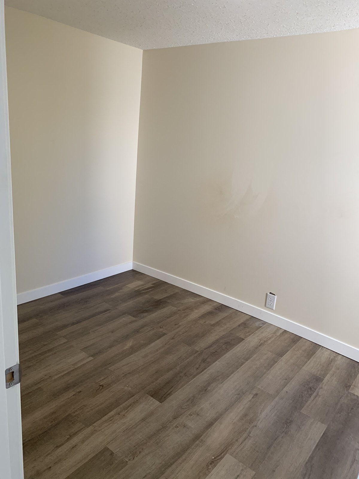 an empty room with wooden floors and white walls