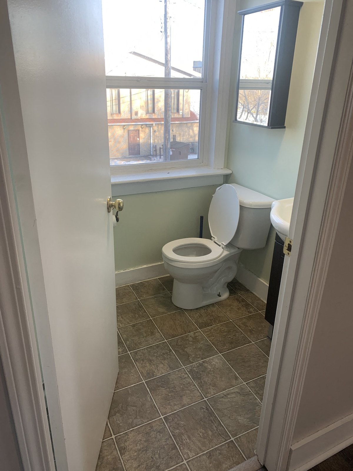 a bathroom with a toilet and a window