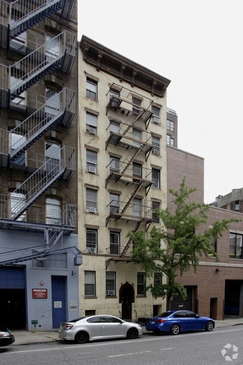 a tall building with stairs on the side of a street