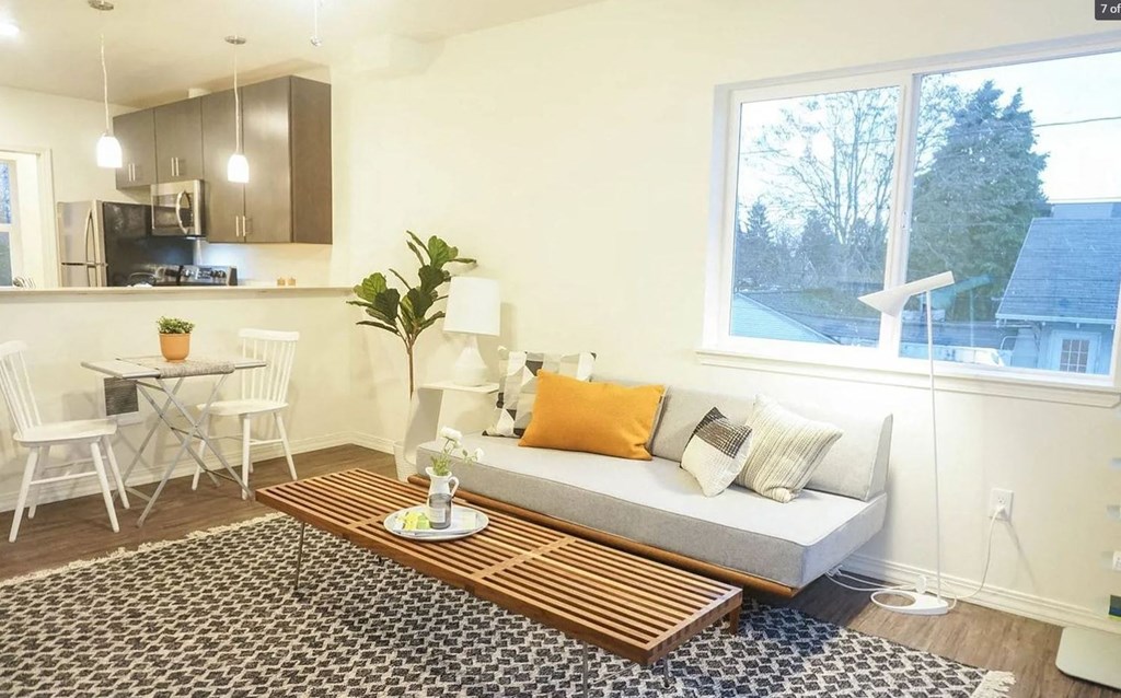 a living room with a couch and a kitchen with a table