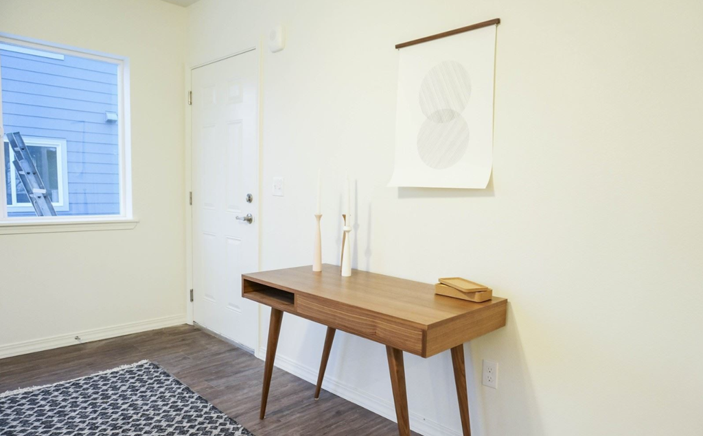 a small desk in a room with a painting on the wall