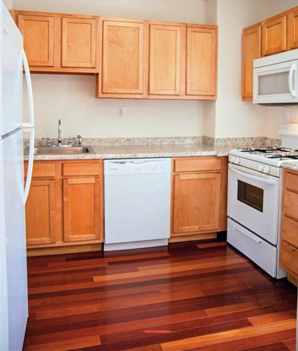 a kitchen with wooden floors and white appliances