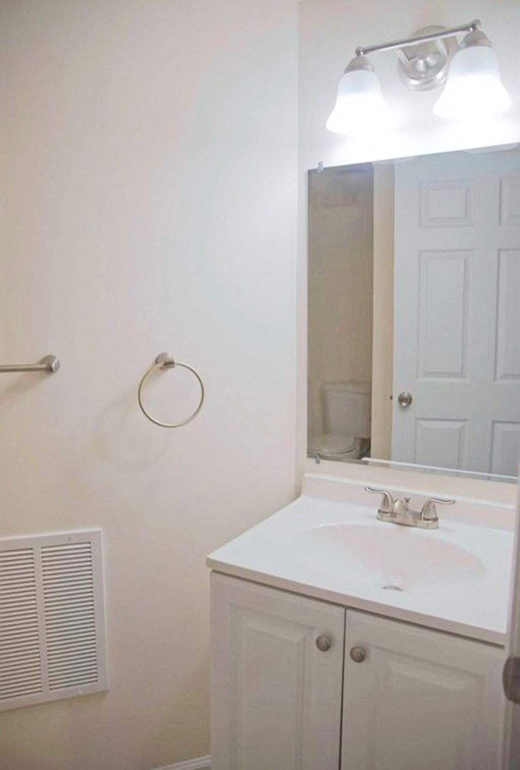 a white bathroom with a sink and a mirror