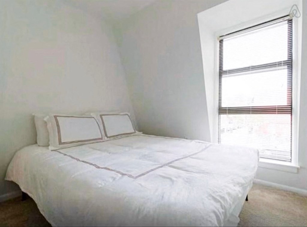 a small bedroom with a bed and a window