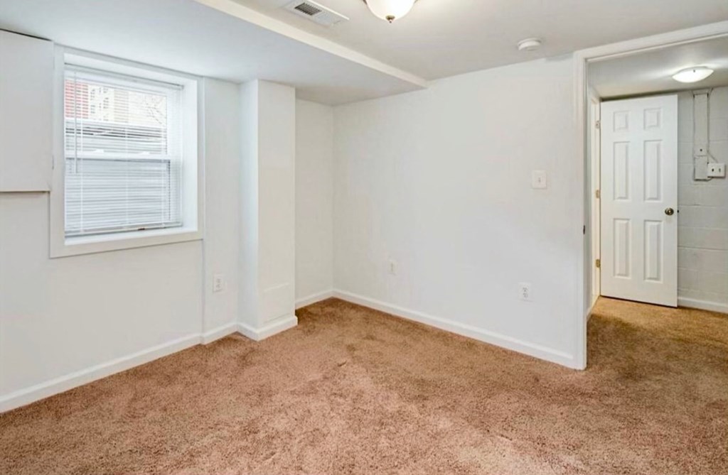 an empty living room with a window and a door