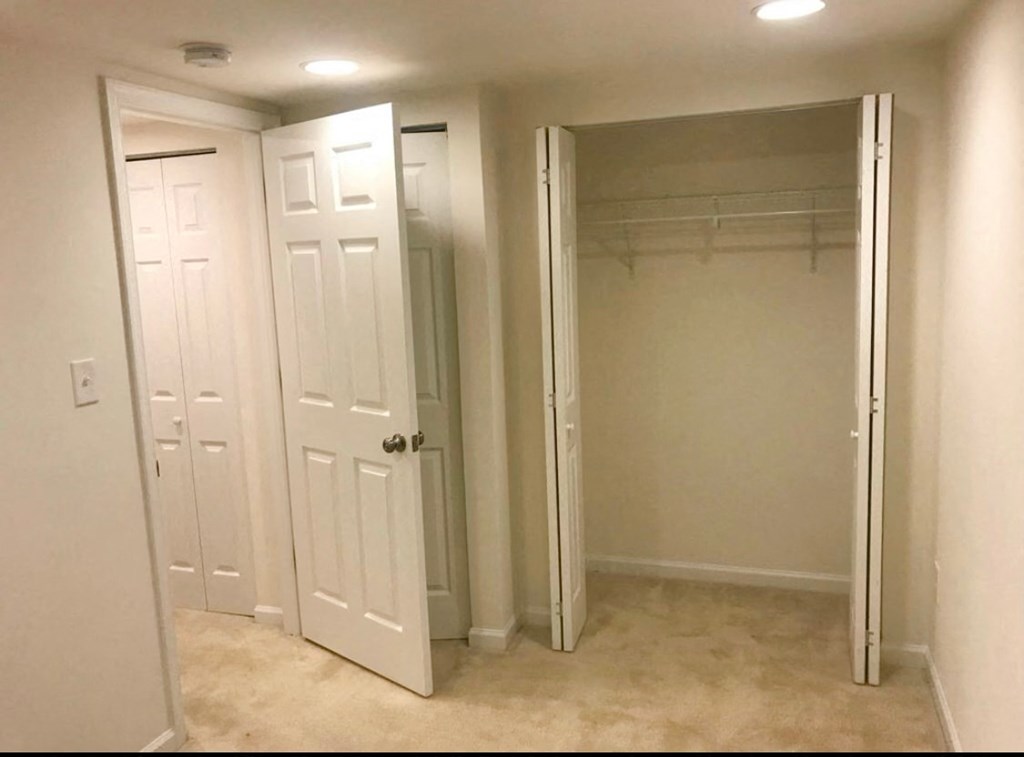 a bedroom with a closet and a closet mirror and a door to a closet