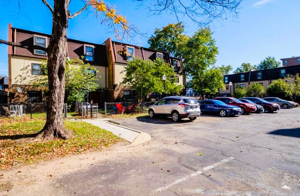 a parking lot with cars parked in front of an apartment building