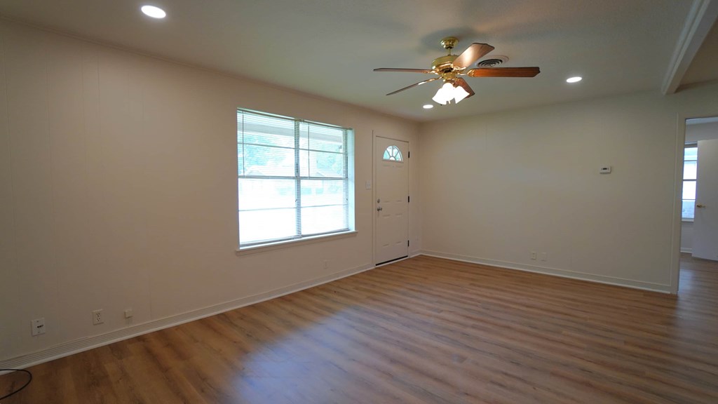 a living room with a ceiling fan and a window