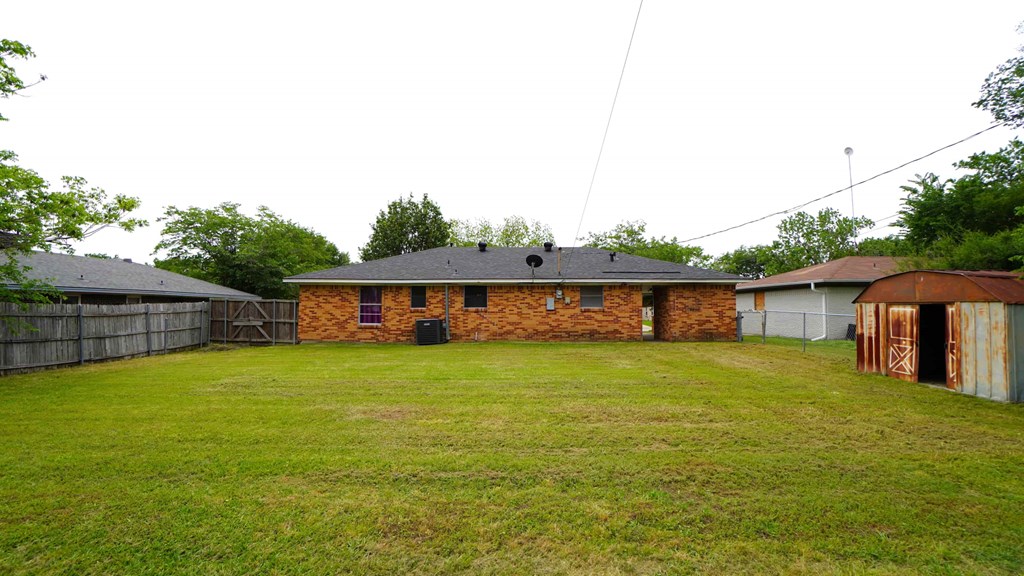a backyard with a yard and a brick house