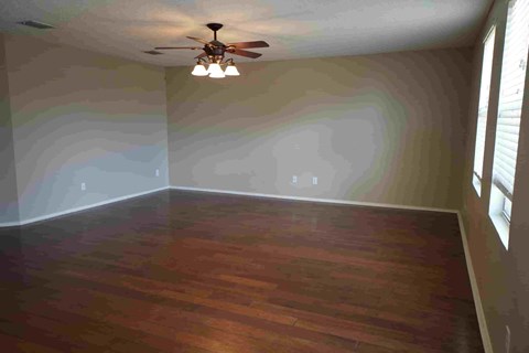 a empty living room with a ceiling fan