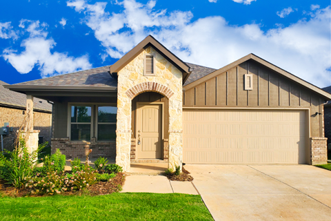 A house with a stone archway entrance and a garage door.