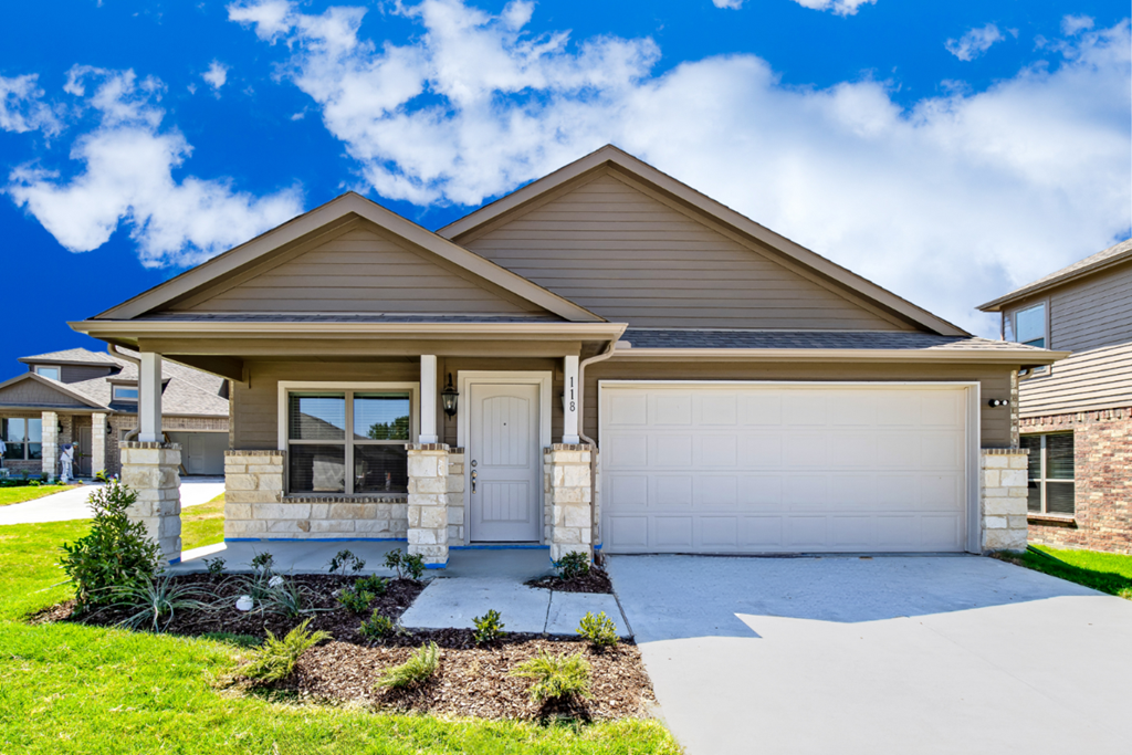A house with a white garage door and a brown roof.