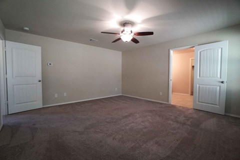a empty living room with a ceiling fan
