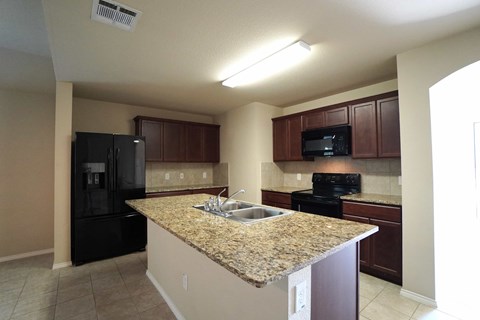a kitchen with black appliances and a granite counter top