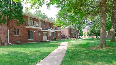 a row of brick apartment buildings with a sidewalk