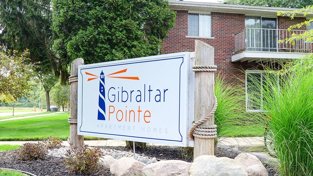 a sign for the gibraltar point apartments in front of a building