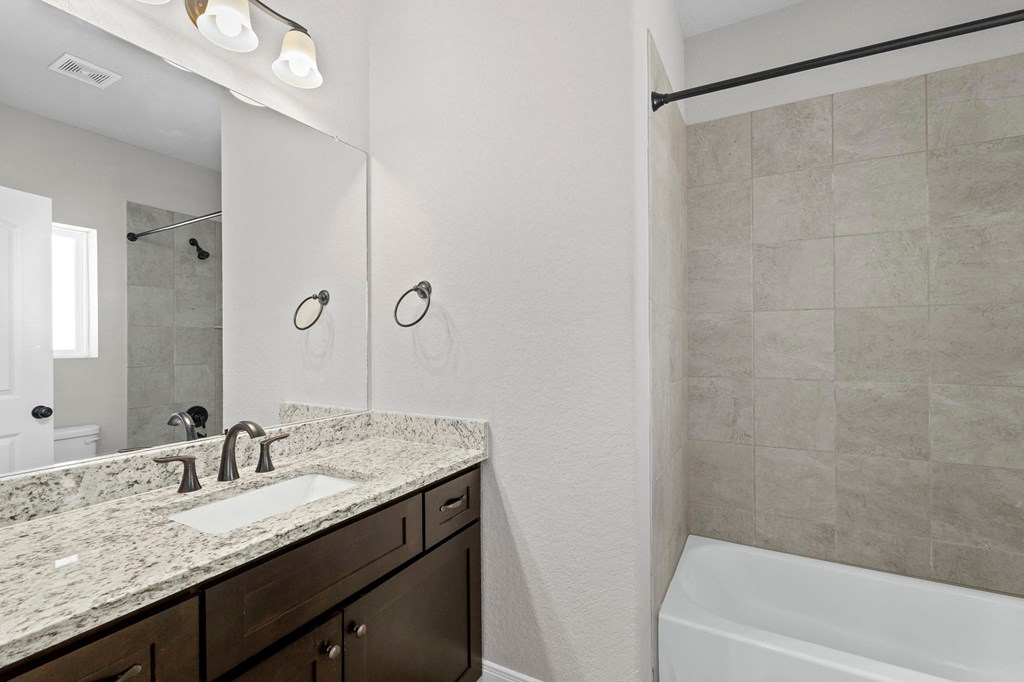 a bathroom with a sink and a shower and a tub