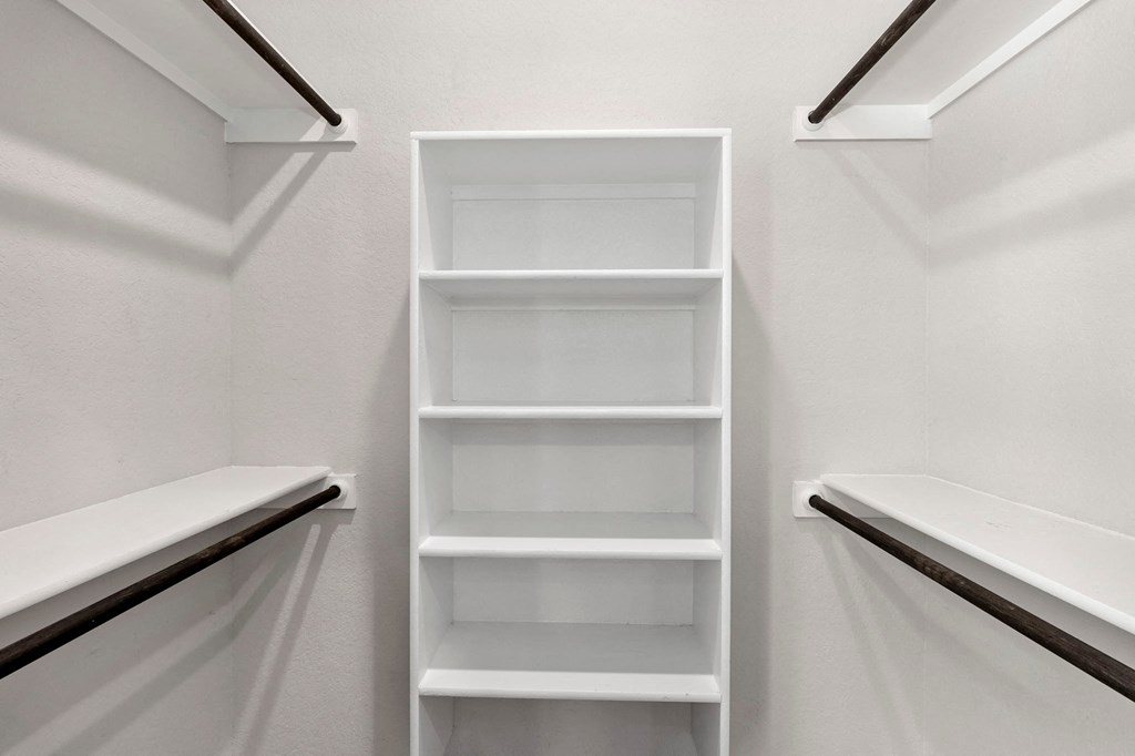 a white closet with white shelves and white walls