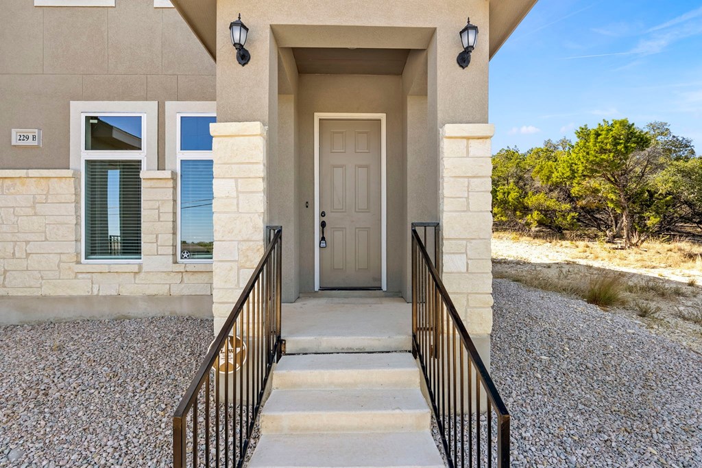 the front door of a building with stairs and a gate