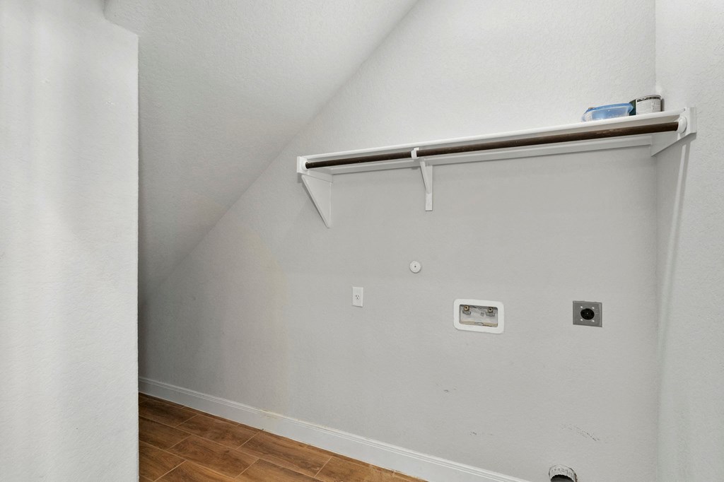 a room with a white wall with a sliding door and a shelf on the wall