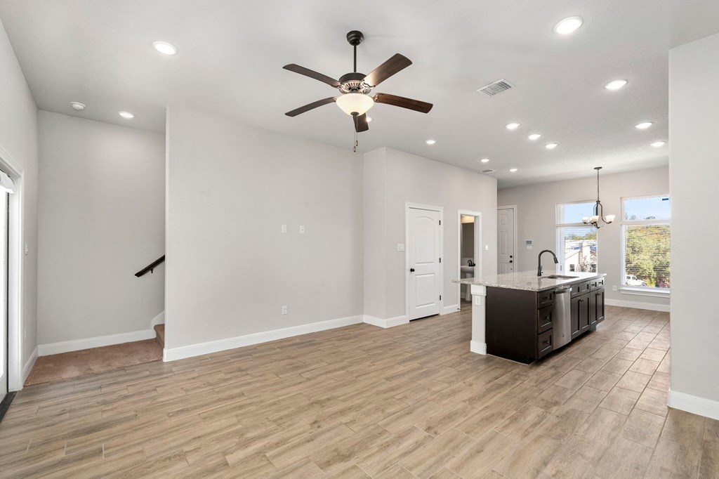 an open kitchen and living room with a ceiling fan
