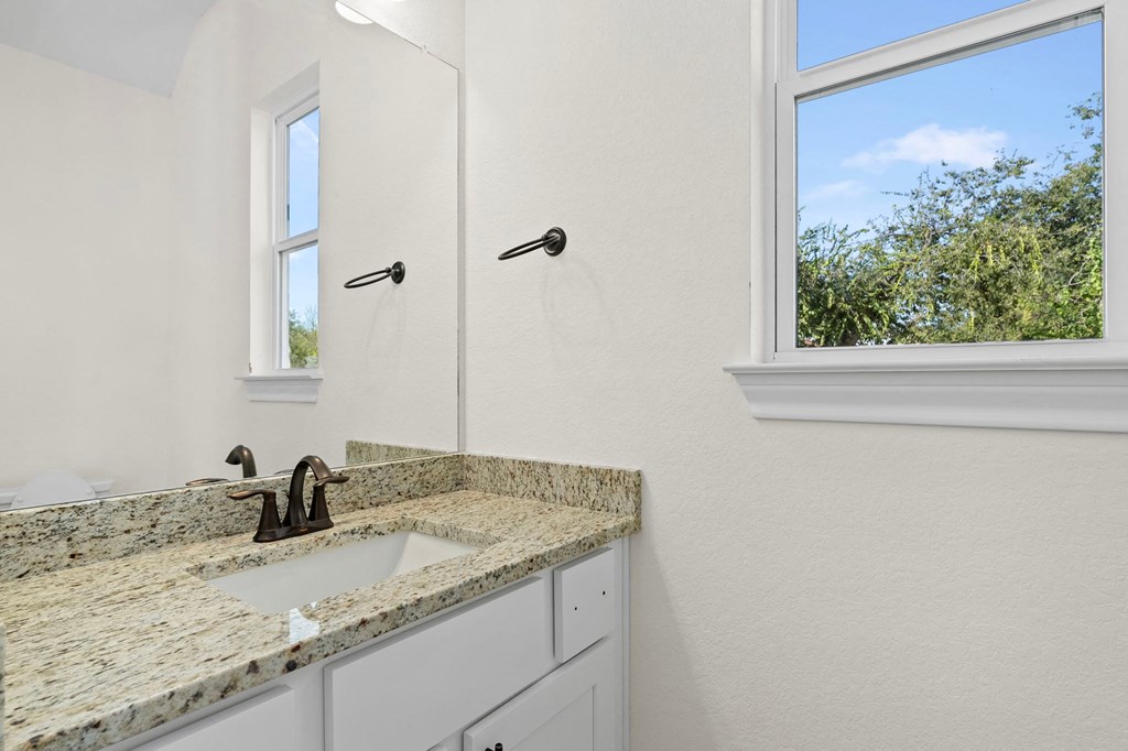 a bathroom with a sink and a shower and a window